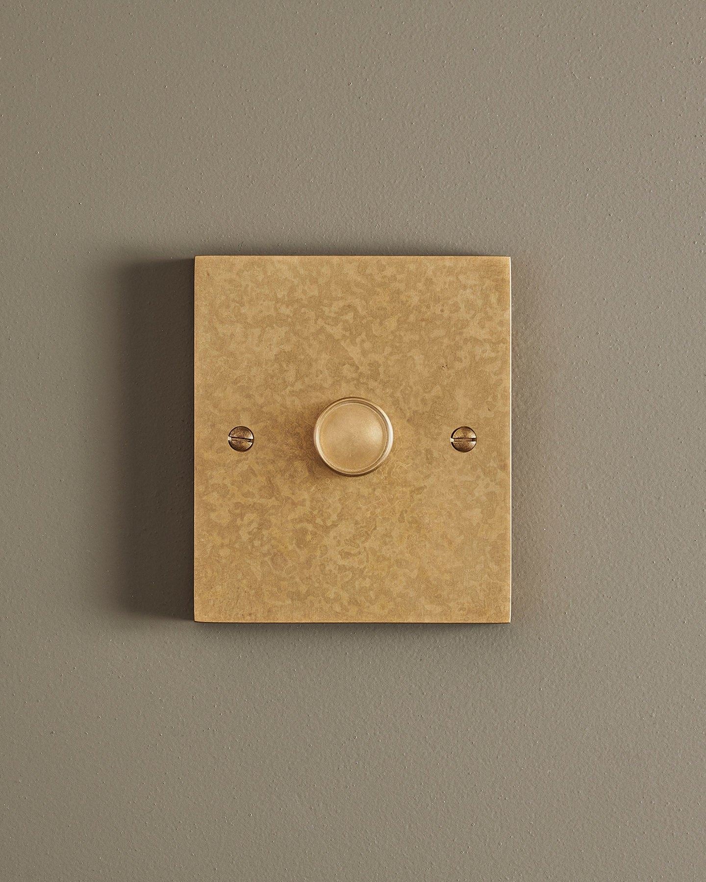 A straight-on view of a 1 gang box dimmer switch in a mottled aged brass finish.