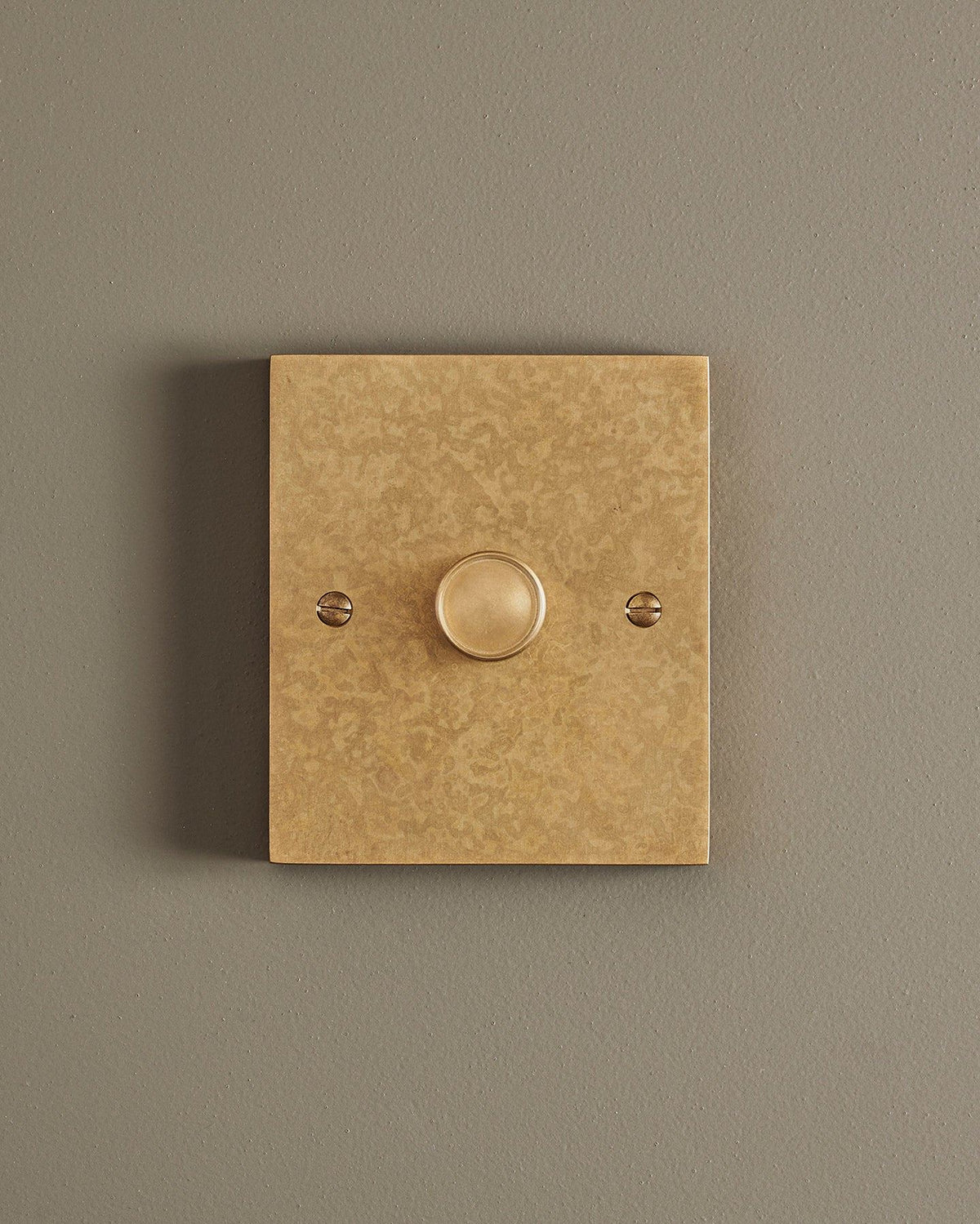 A straight-on view of a 1 gang box dimmer switch in a mottled aged brass finish. TEST