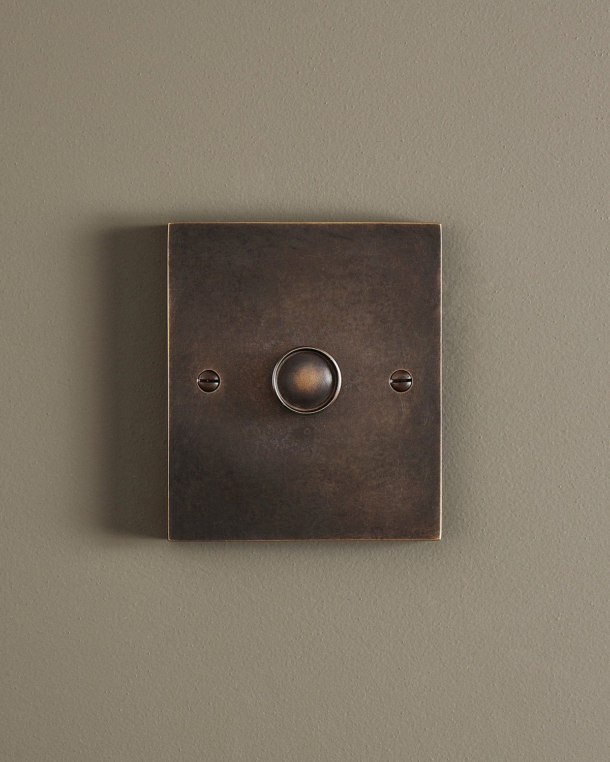 A straight-on view of a 1 gang box dimmer switch in a dark oxidised brass finish. TEST