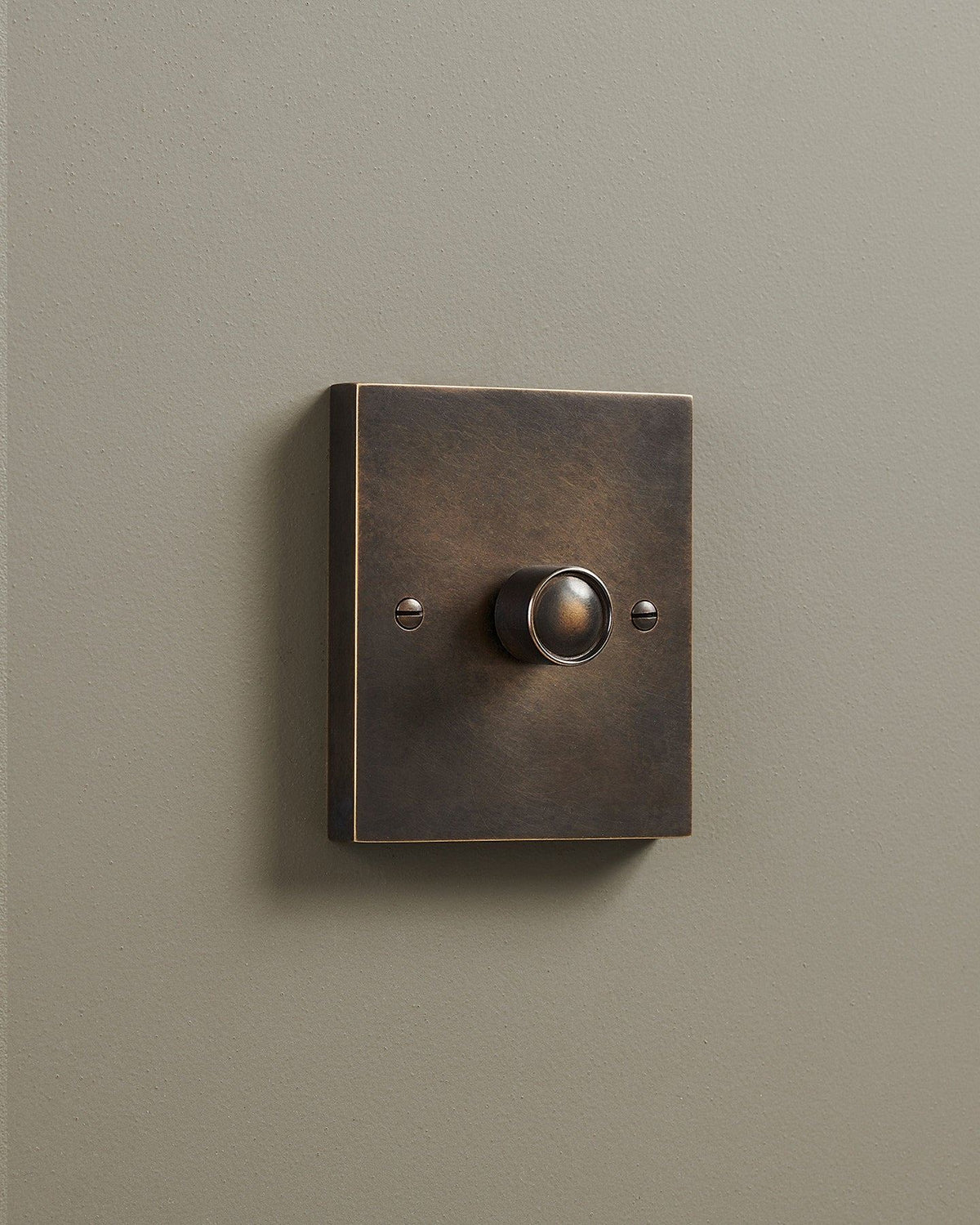 An oblique view of a 1 gang box dimmer switch in a dark oxidised brass finish. TEST