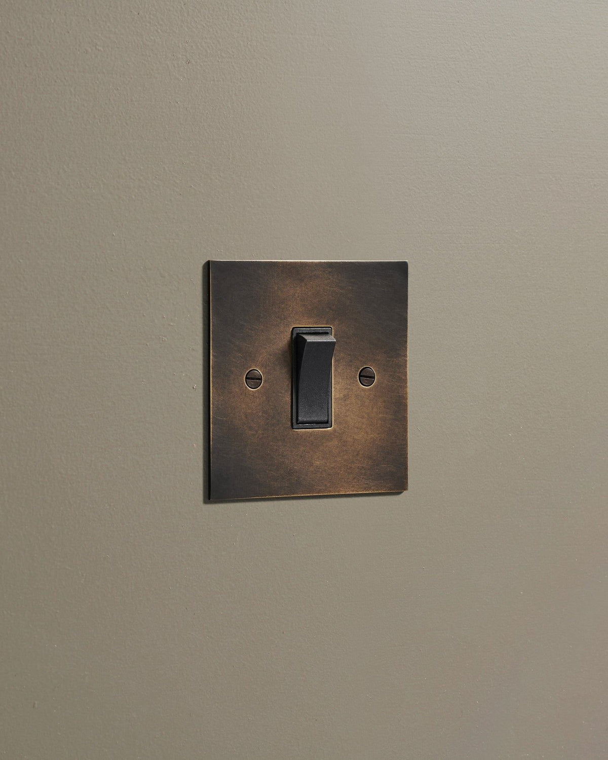 An oblique view of a classic 20 amp switch in a dark oxidised brass finish. TEST