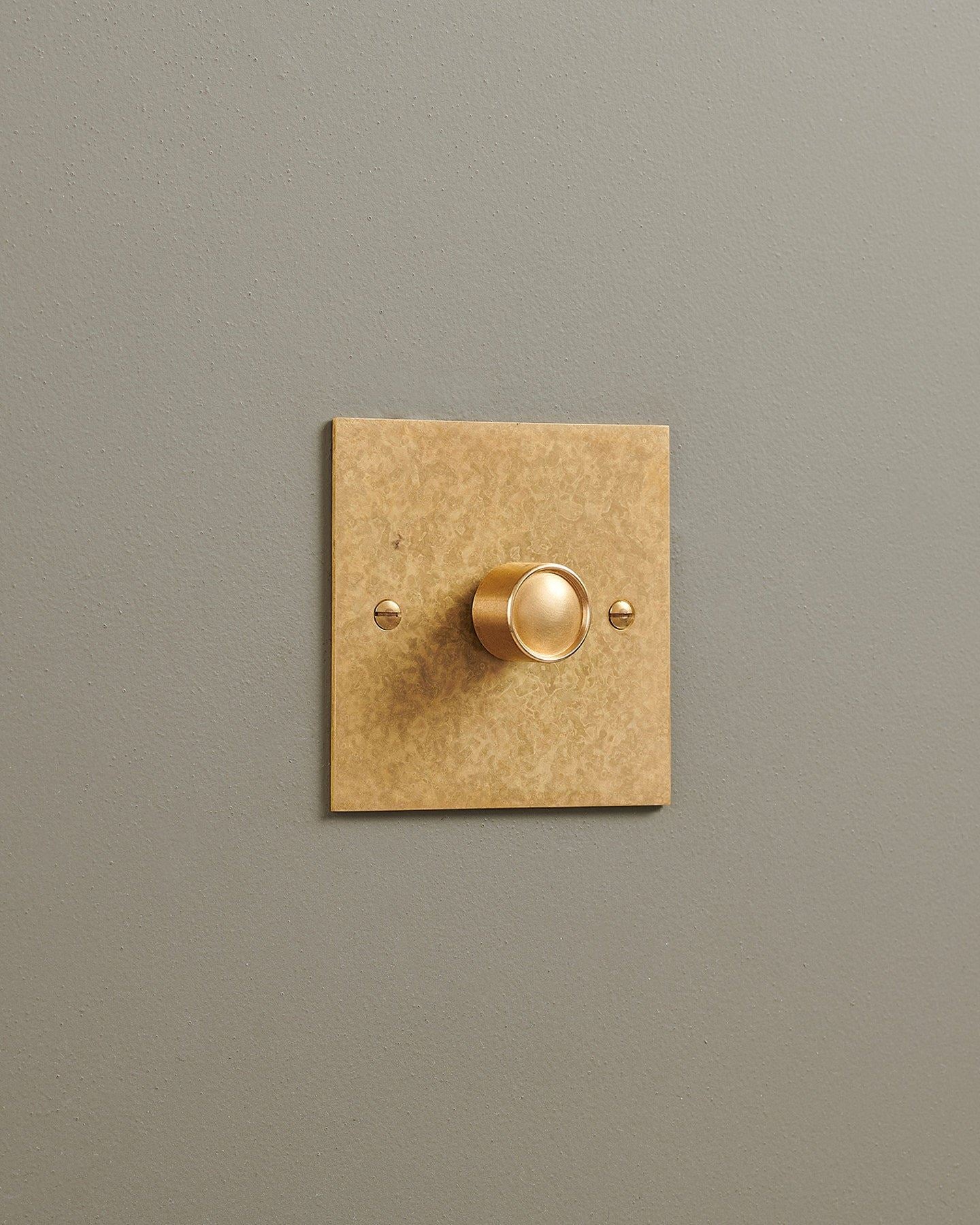 An oblique view of a 1 gang classic dimmer switch in a mottled aged brass finish.