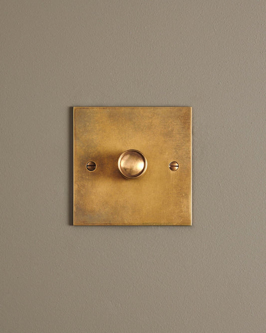 A straight-on view of a 1 gang classic dimmer switch in a warm burnished brass finish.