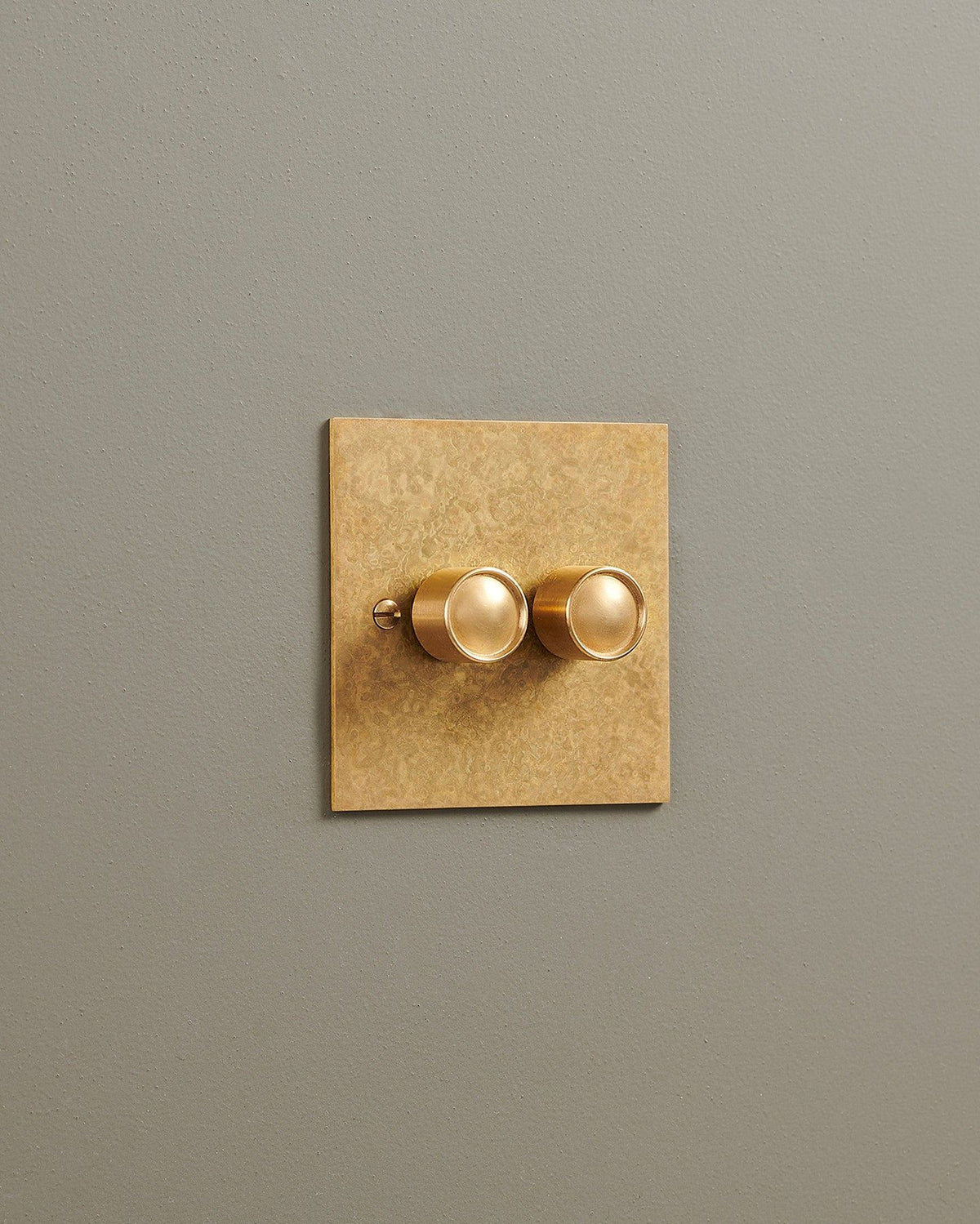 An oblique view of a 2 gang classic dimmer switch in a mottled aged brass finish. TEST