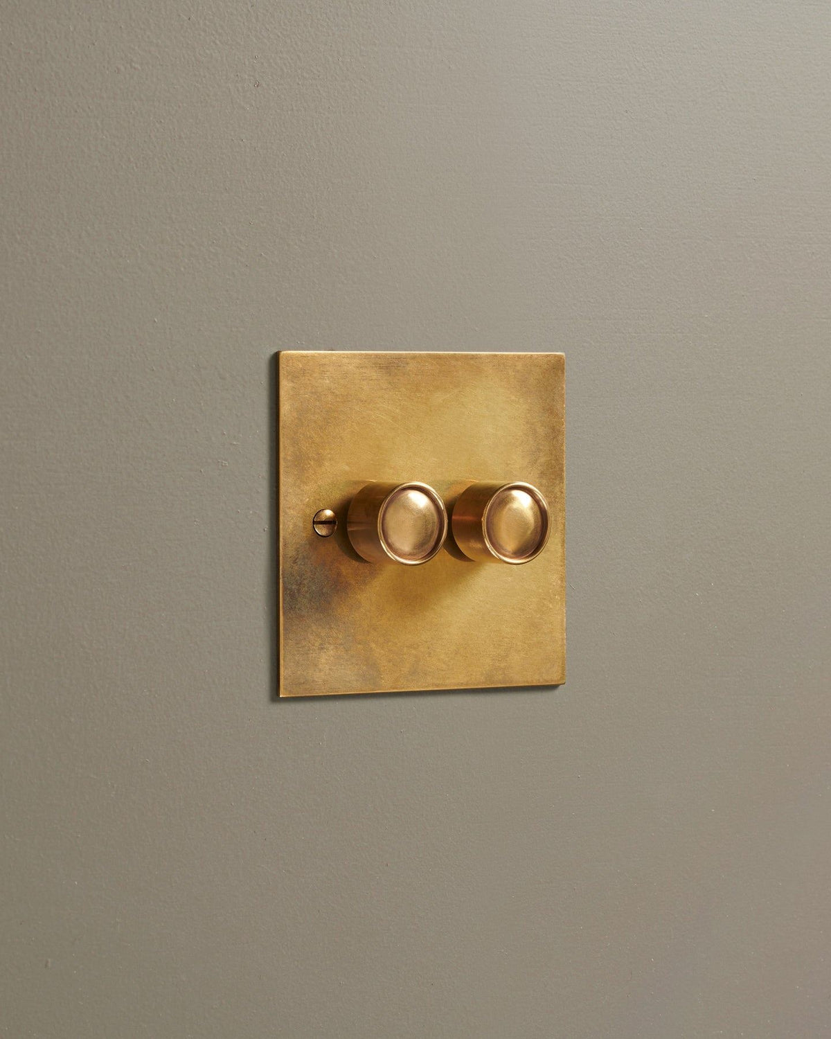 An oblique view of a 2 gang classic dimmer switch in a warm burnished brass finish. TEST