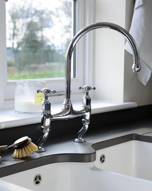 A close-up oblique view of a traditional-style chrome mixer tap with crosshead handles.