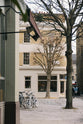 Beyond winter trees, cobblestones, and bike racks is a tall historical townhouse located at a corner in the heart of London, which has been beautifully renovated in a shade known as Princelet pink. The building still showcases its original brick texture. Above the entrance door is the deVOL logo in black with a gold-rimmed shadow.