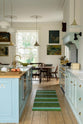 Nestled between a classic English kitchen featuring a cooker and sink run with a Carrara marble worktop, a suspended false chimney breast, a glazed wall cupboard, and a kitchen island with Carrara marble on one side and solid oak on the other, the cosy breakfast nook creates a seamless flow within the space.