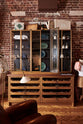 A closer look at the open base cabinets with internal drawers, countertop glazed cupboards, and a copper worktop as part of the handsome range of oak furniture and lighting from the deVOL Haberdasher’s collection. Adorned with the Grand tour reading lamp, vintage furniture and items, the Heirloom collection, and 1900s tailor tools, this space creates a beautiful homage to the English gentlemen’s haberdashery inspiration in a bricked wall showroom.