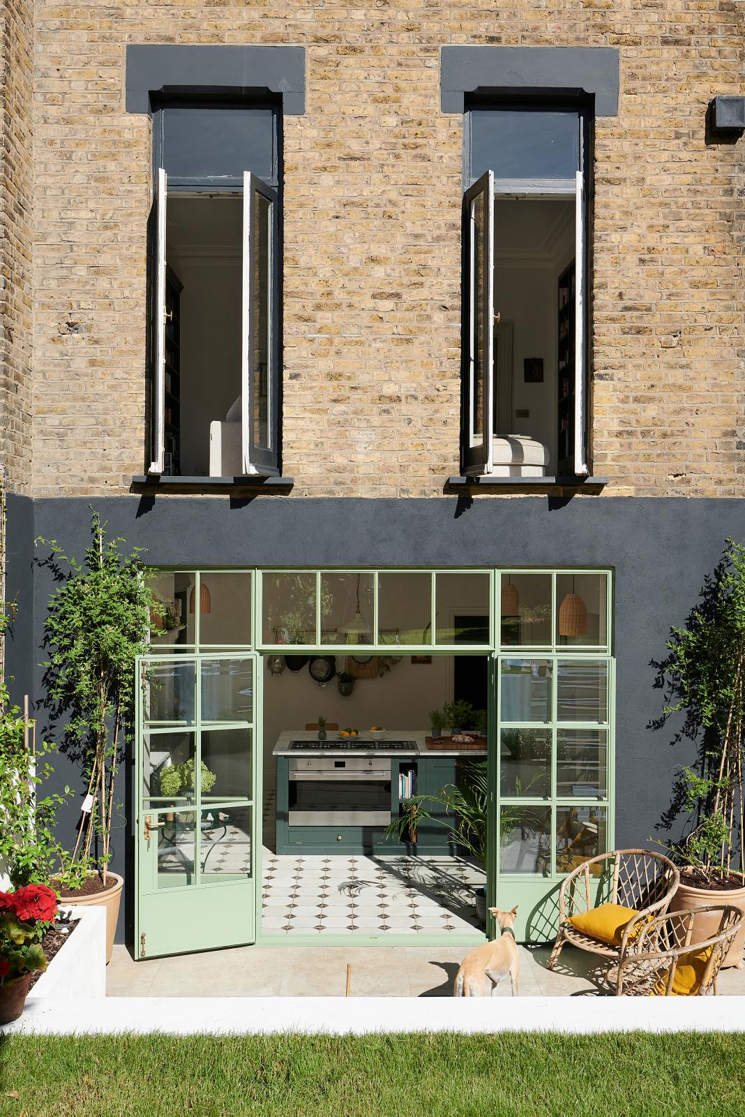 A top-down view of the wide Crittall windows painted pistachio green, alongside the Bakehouse Green shaker kitchen with the reclaimed octagonal marble-tiled floor awaiting inside.