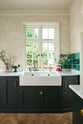 A closer look at the double Belfast sink with an aged brass Ionian tap in the Bakehouse Green shaker kitchen’s sink run, featuring Carrara marble worktop. At the nook are the Emerald Green London tiles, which add colour to the off-white, delicately patterned wallpaper.
