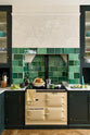 A closer look at the cream gas stove in the Bakehouse Green shaker kitchen’s sink run, featuring Carrara marble worktop. At the nook are the Emerald Green London tiles, which add colour to the off-white, delicately patterned wallpaper.