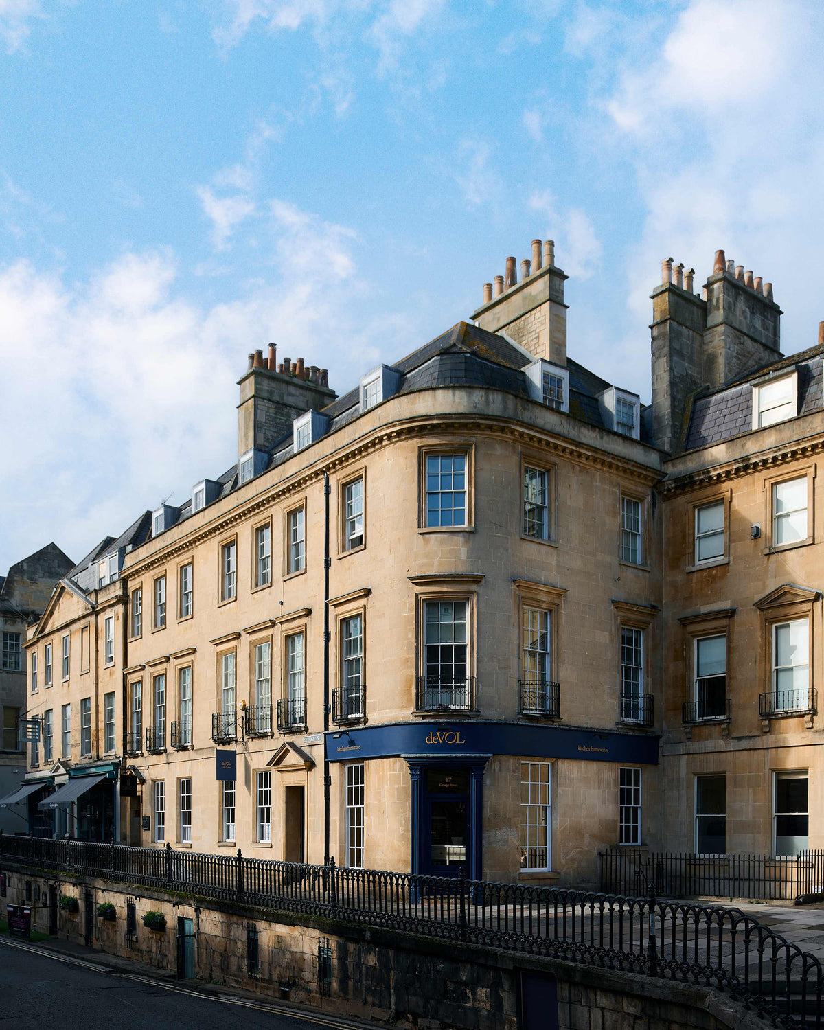 The deVOL George Street, Bath showroom is a traditional tall, three floor, bath stone building with the iconic deVOL blue on the rim of the pillars of the front door, signs and a golden deVOL logo.