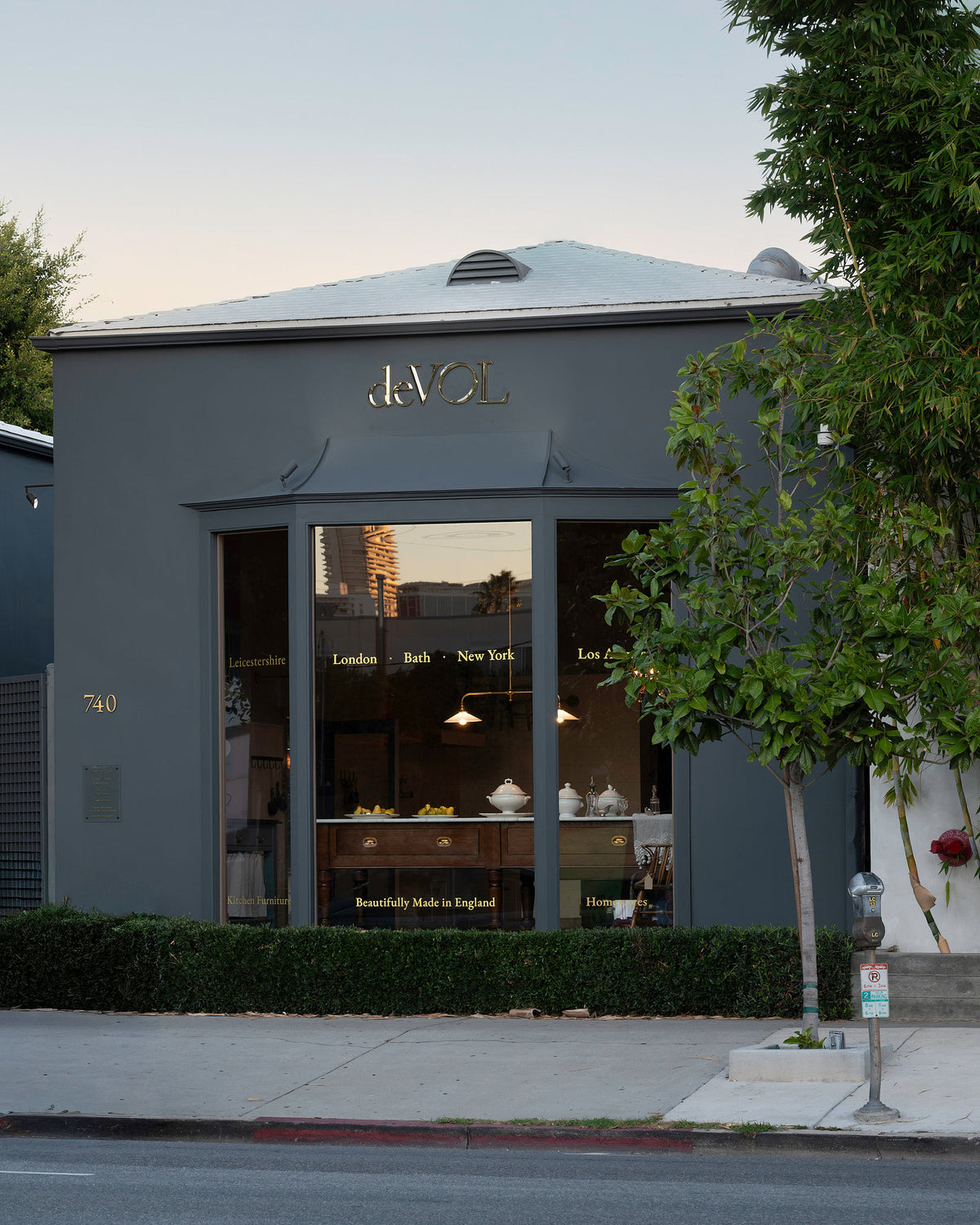 The deVOL La Cienega Blvd, Los Angeles showroom is a one floor, tall but long building with wide showroom windows at the front, golden signage.
