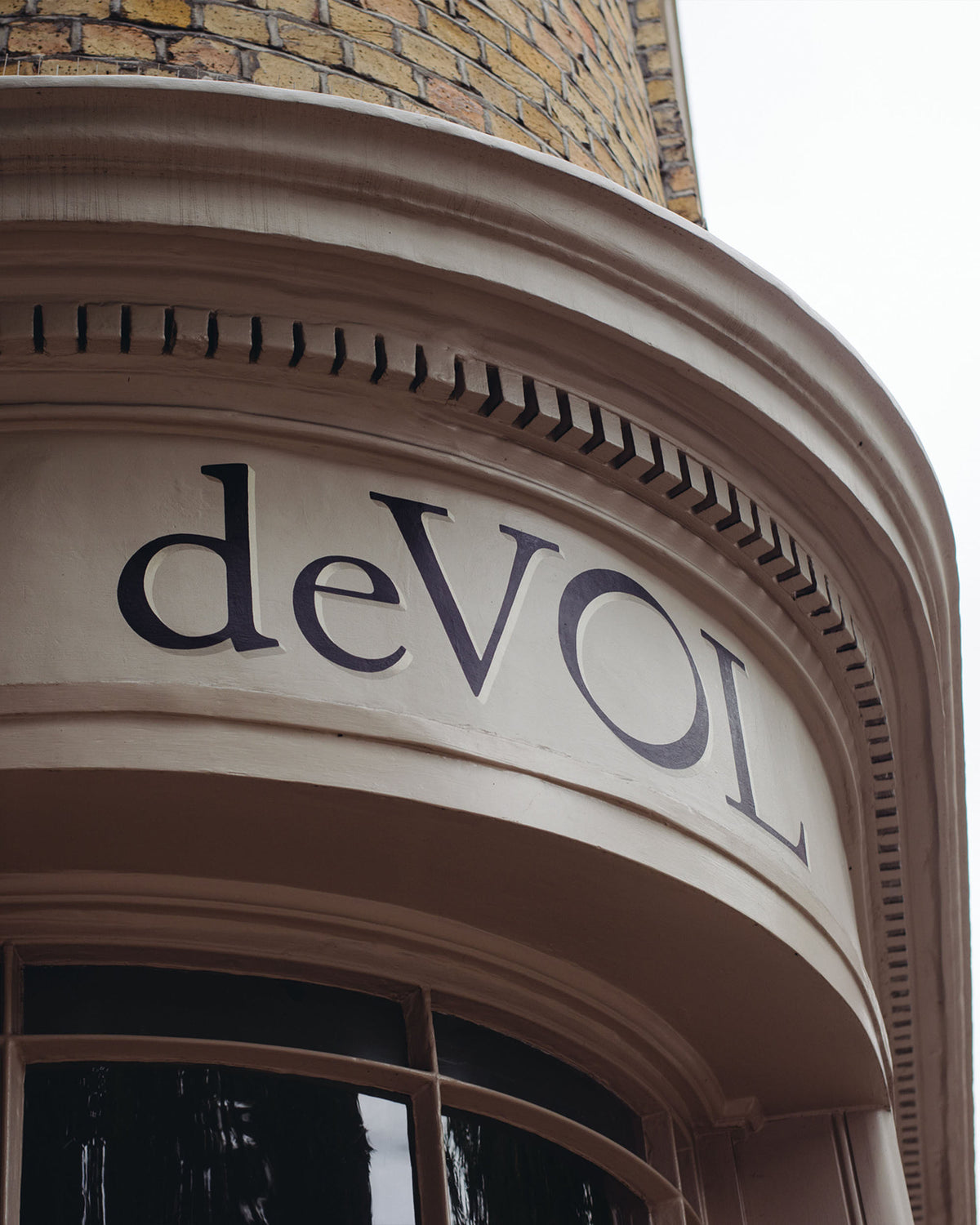 A close-up of deVOL's St John's Square showroom's building logo. Hand painted in black with gold.