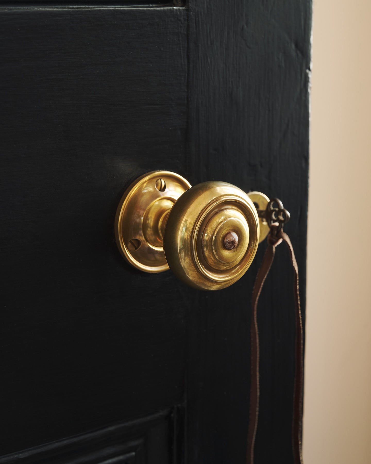 A tight view of the brass knob’s decorative rosette plate, highlighting its warm, burnished finish and timeless form.