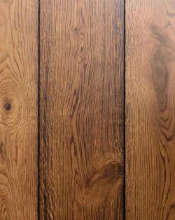A close-up overhead view of oak floorboards with a warm aged finish.