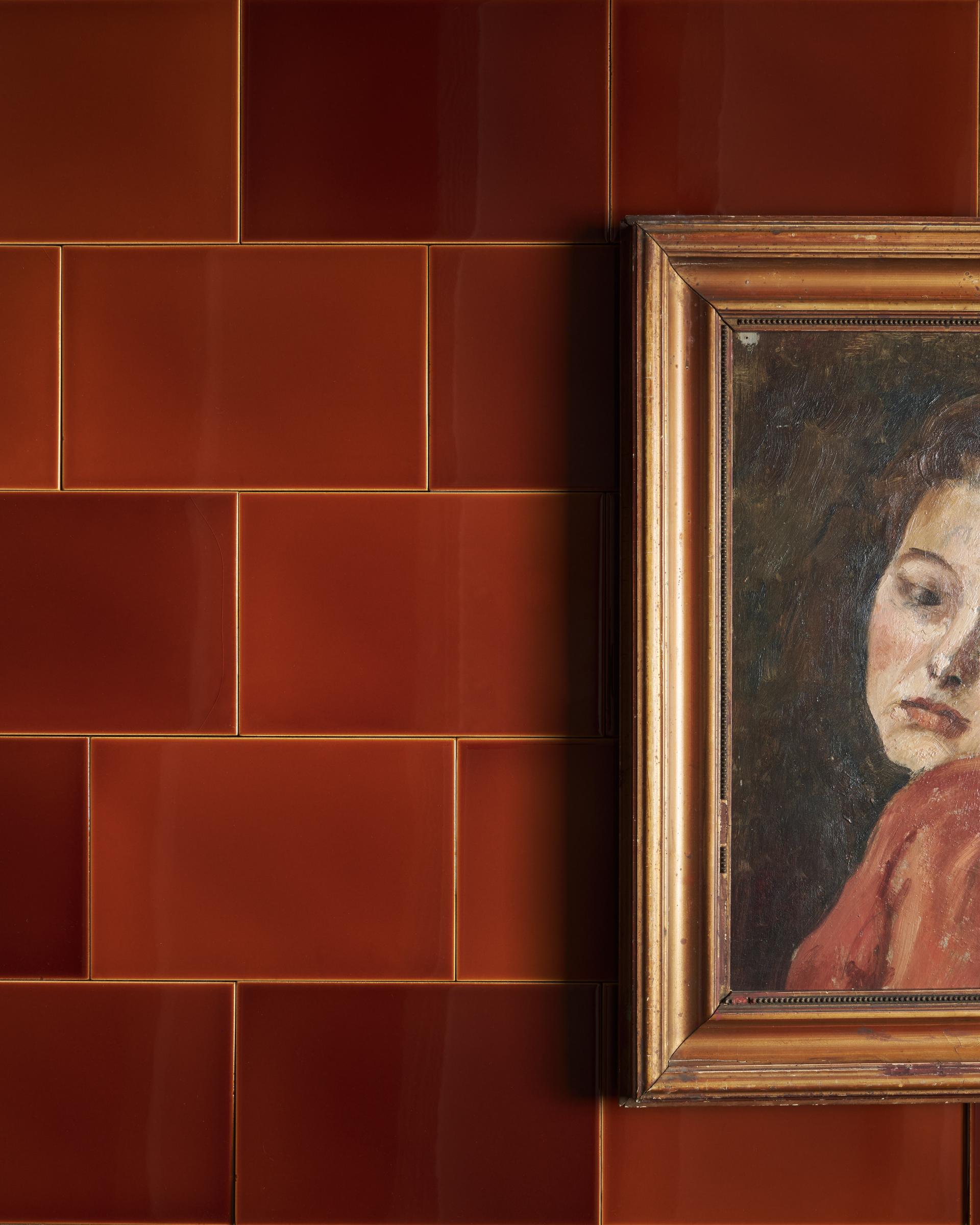 The Kentish brown tiles in various shades and an antique picture frame of a lady in front of the tiles