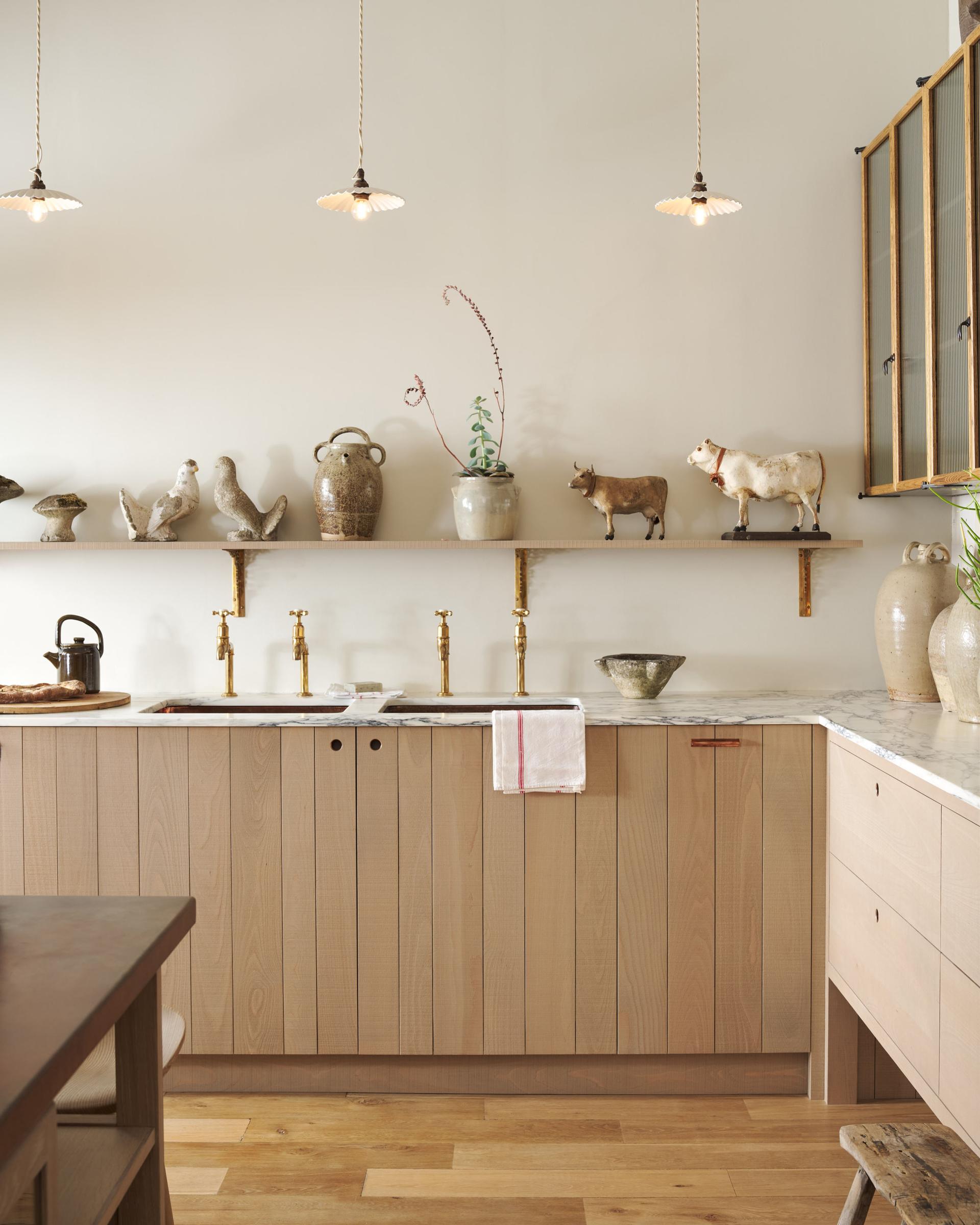 A modern rustic style double sink cupboard with slatted timber doors, natural tones and a Carrara marble worktop.