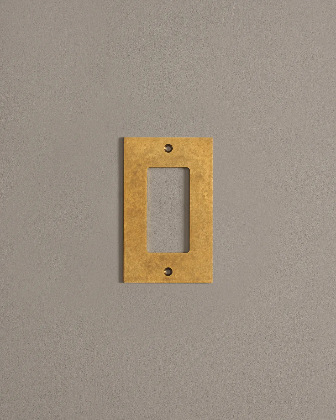 A straight-on view of a 1 gang cover plate in a warm burnished brass finish.