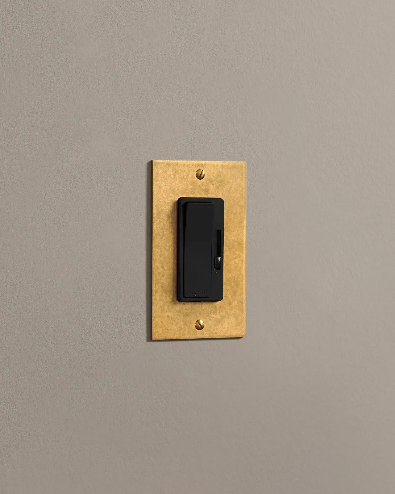 A straight-on view of a 1 gang cover plate in a warm burnished brass finish.