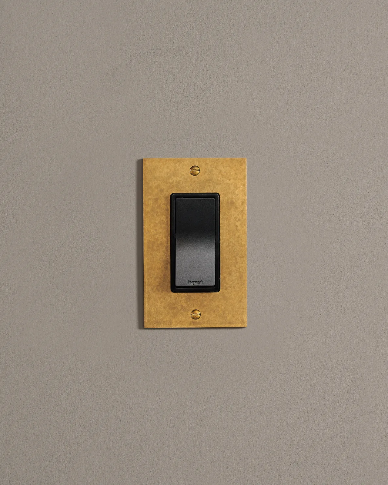 a front on shot of the rocker switch on an aged brass plate.