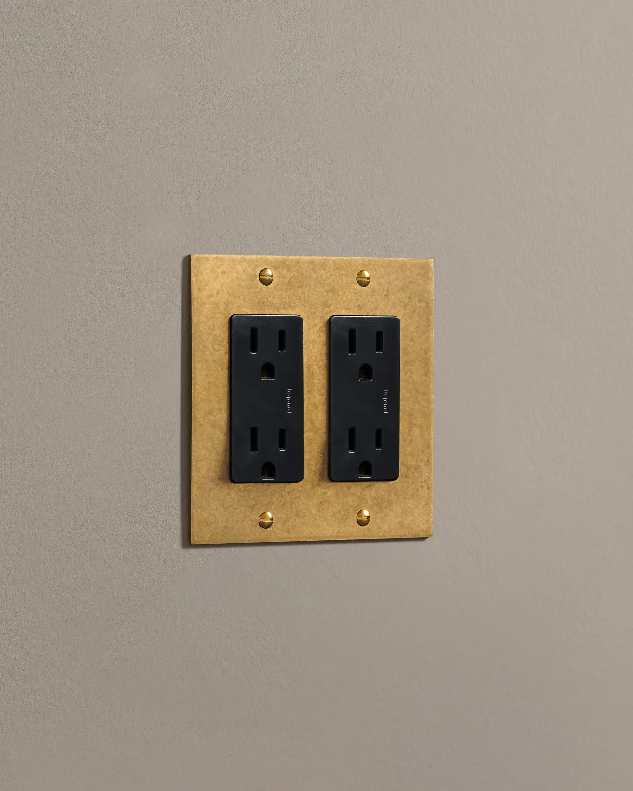 a side on shot of the standard outlet on an aged brass plate.