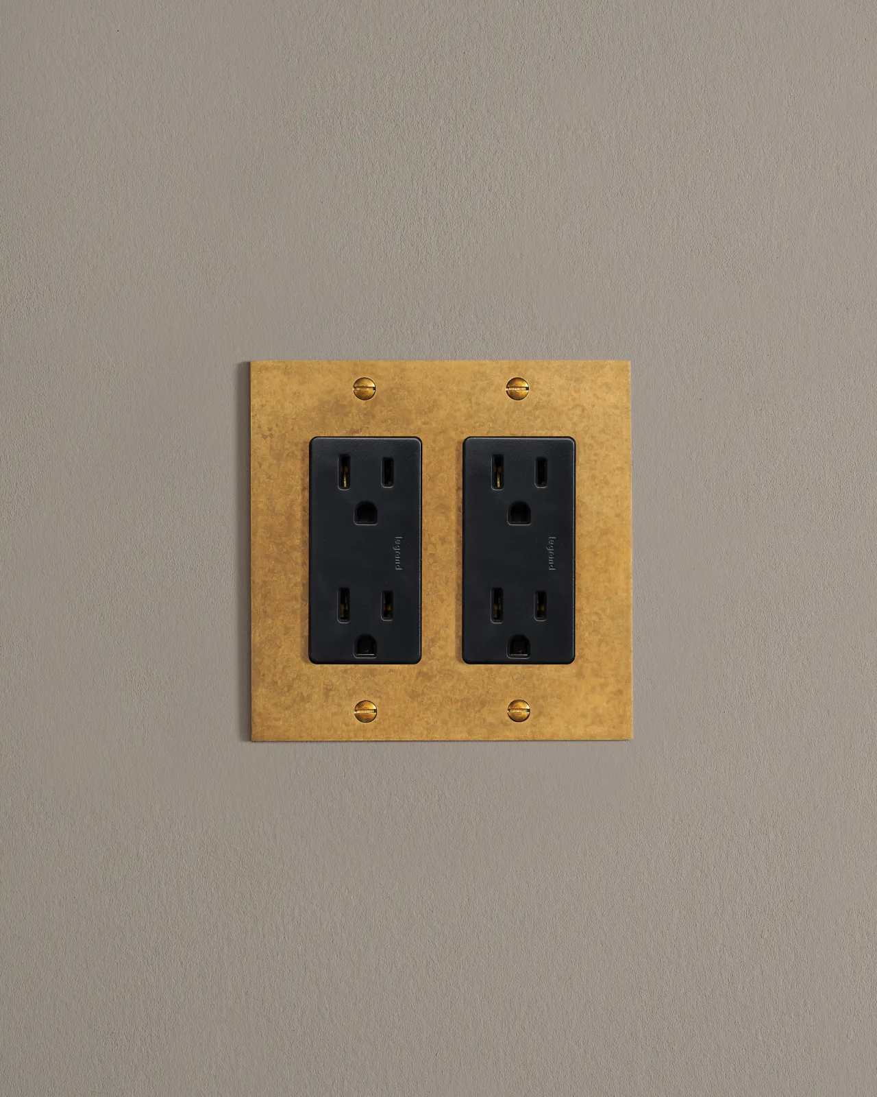 a front on shot of the standard outlet on an aged brass plate.