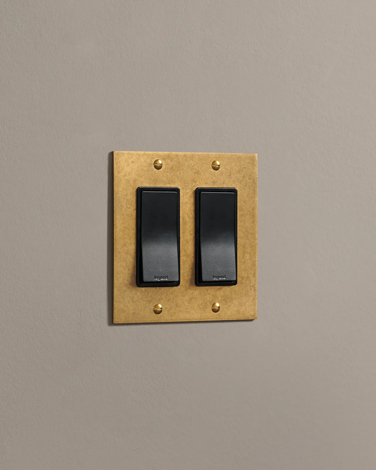 a side on shot of the rocker switch on an aged brass plate.
