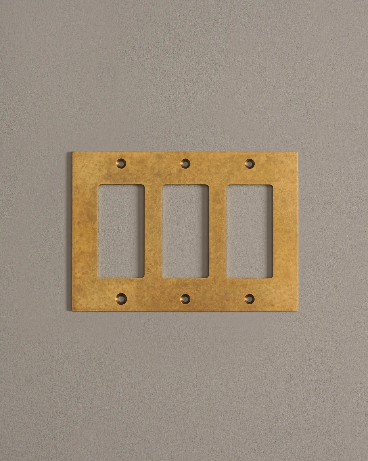 A front on shot of a cover plate in aged brass finish.