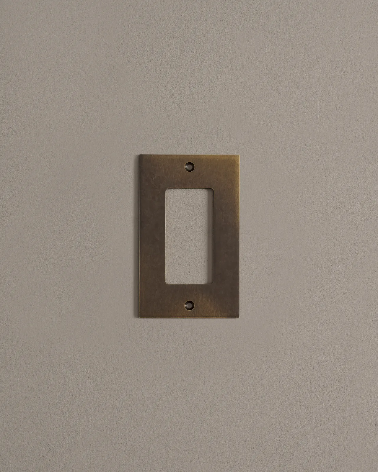 a front on shot of the decora cover plate in oxidised brass finish.