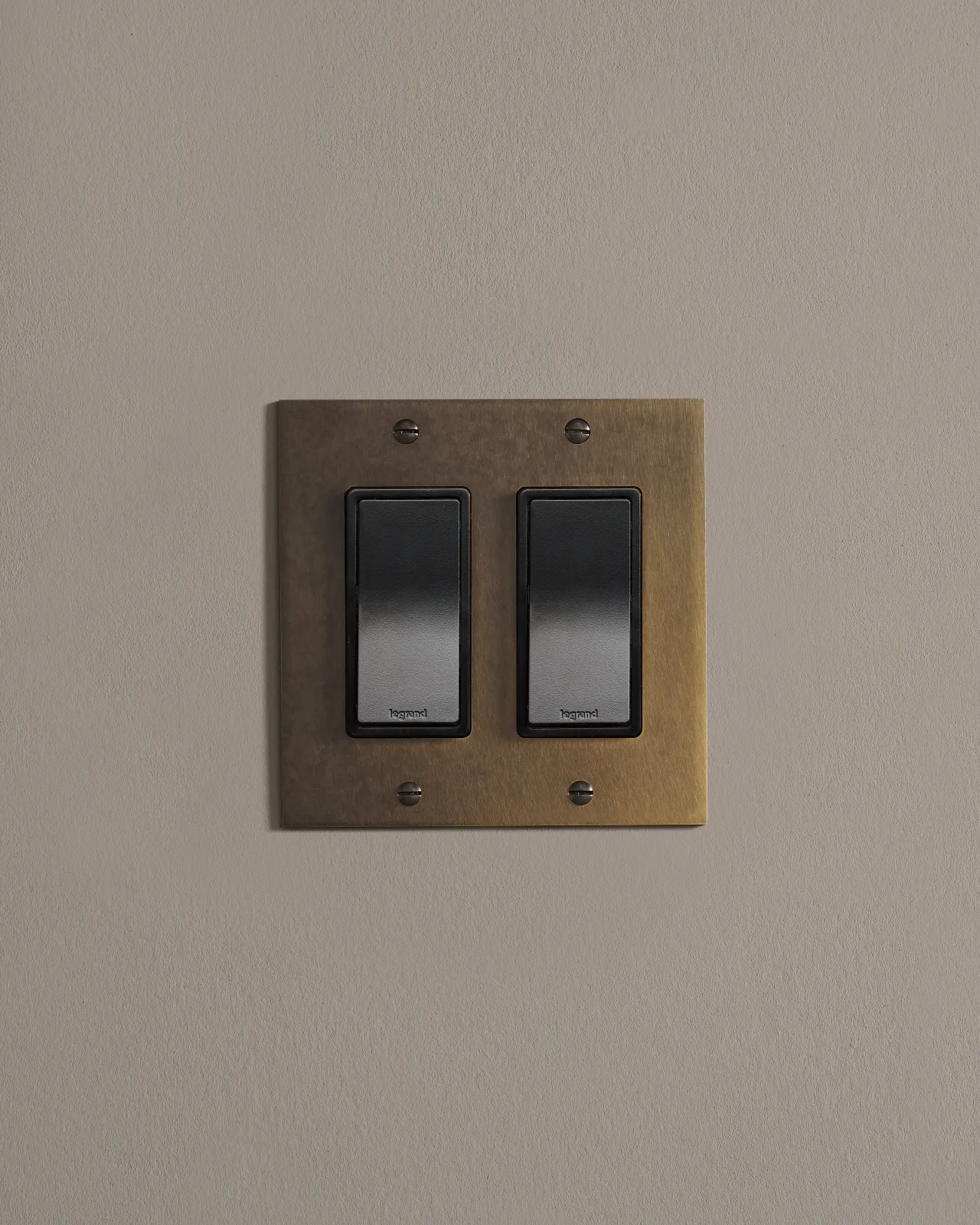 a front on shot of the rocker switch on an oxidised brass plate.