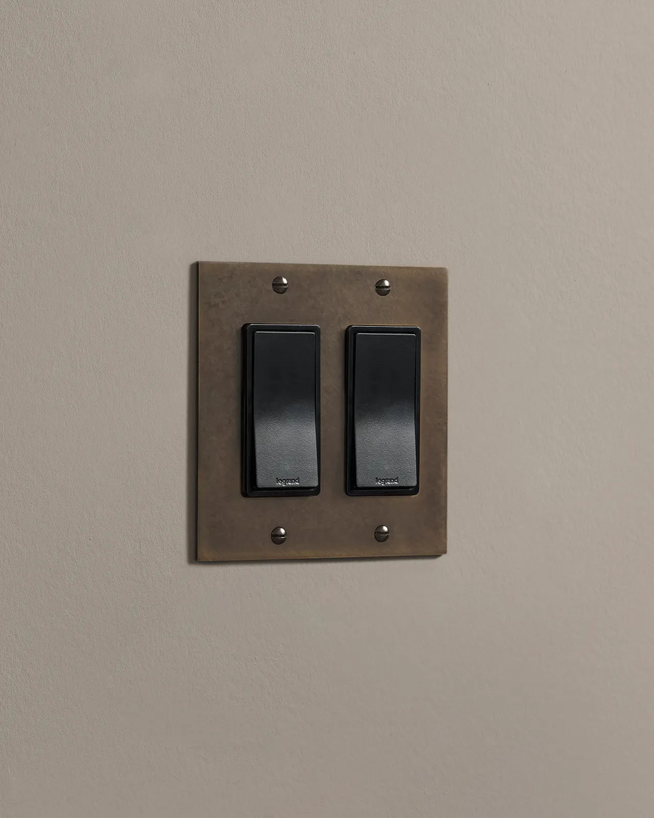 a side on shot of the rocker switch on an oxidised brass plate.