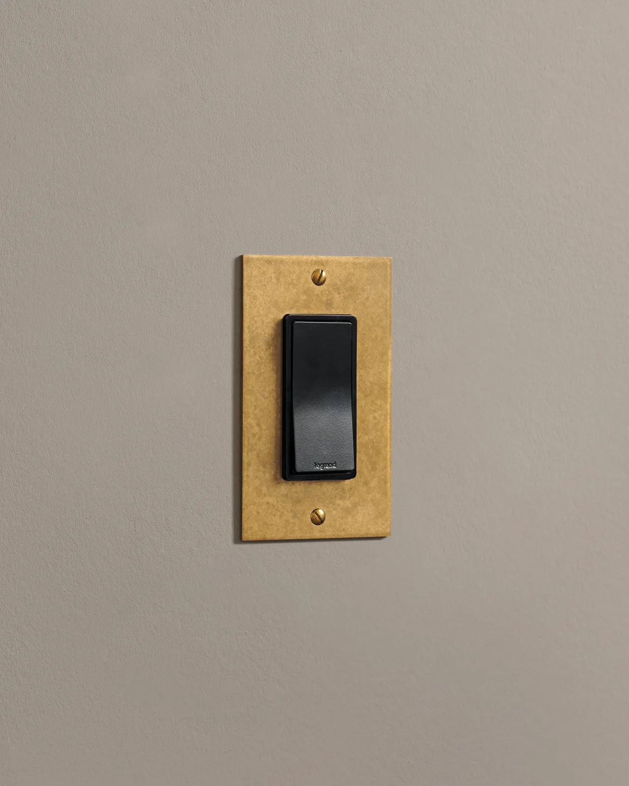 a side on shot of the rocker switch on an aged brass plate.