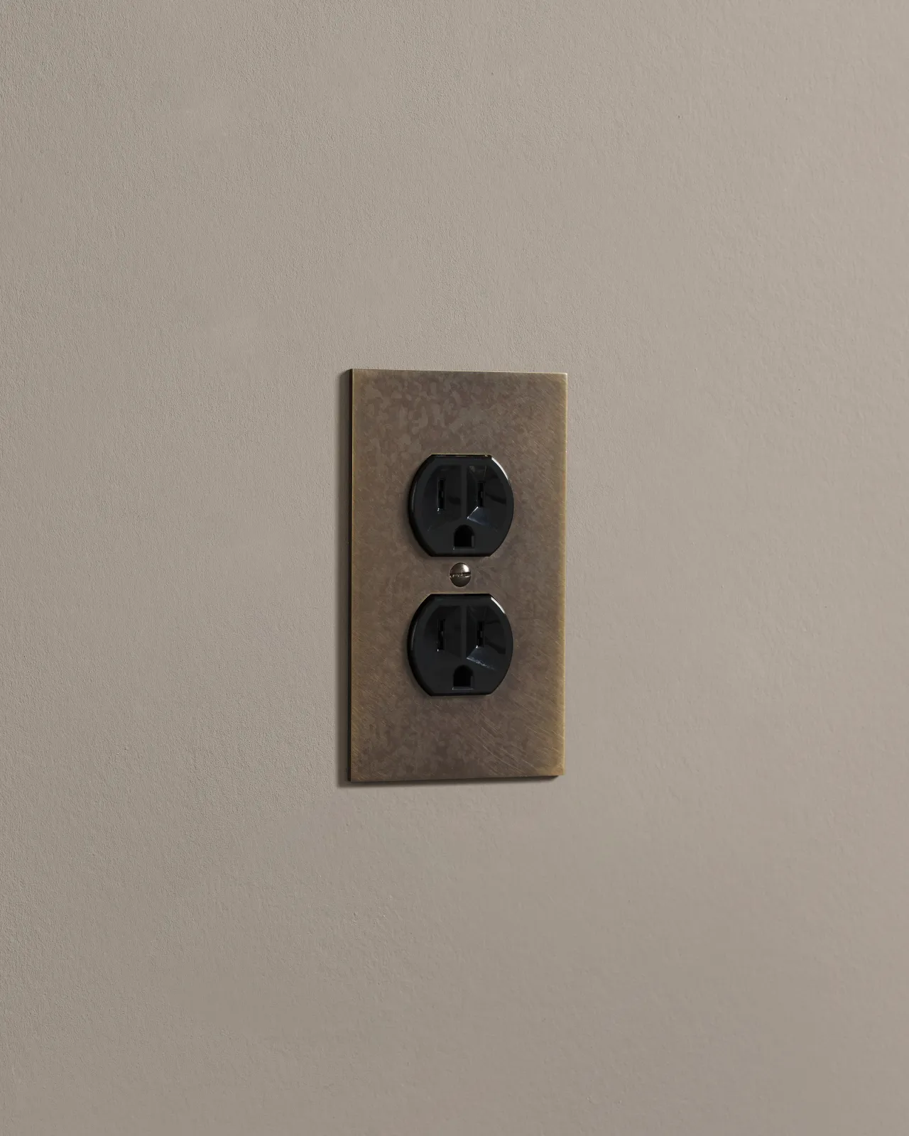 a side on shot of the duplex outlet on oxidised brass cover plate.
