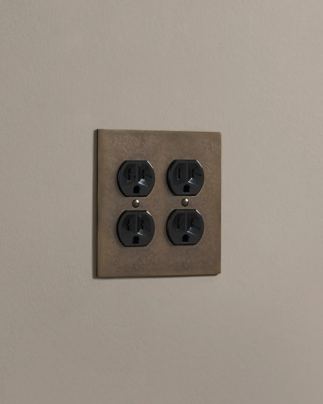 a side on shot of the duplex outlet on oxidised brass cover plate.