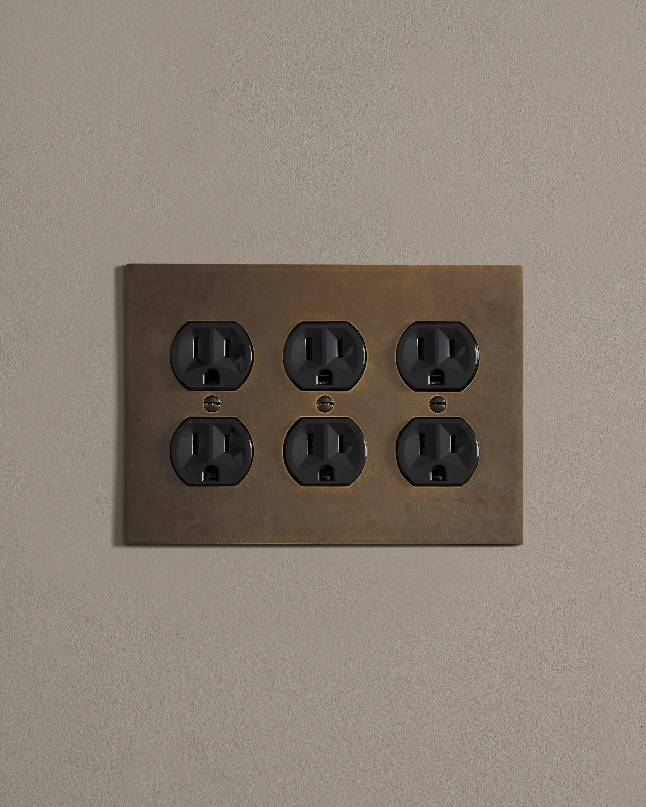 a front on shot of the duplex outlet on oxidised brass cover plate.