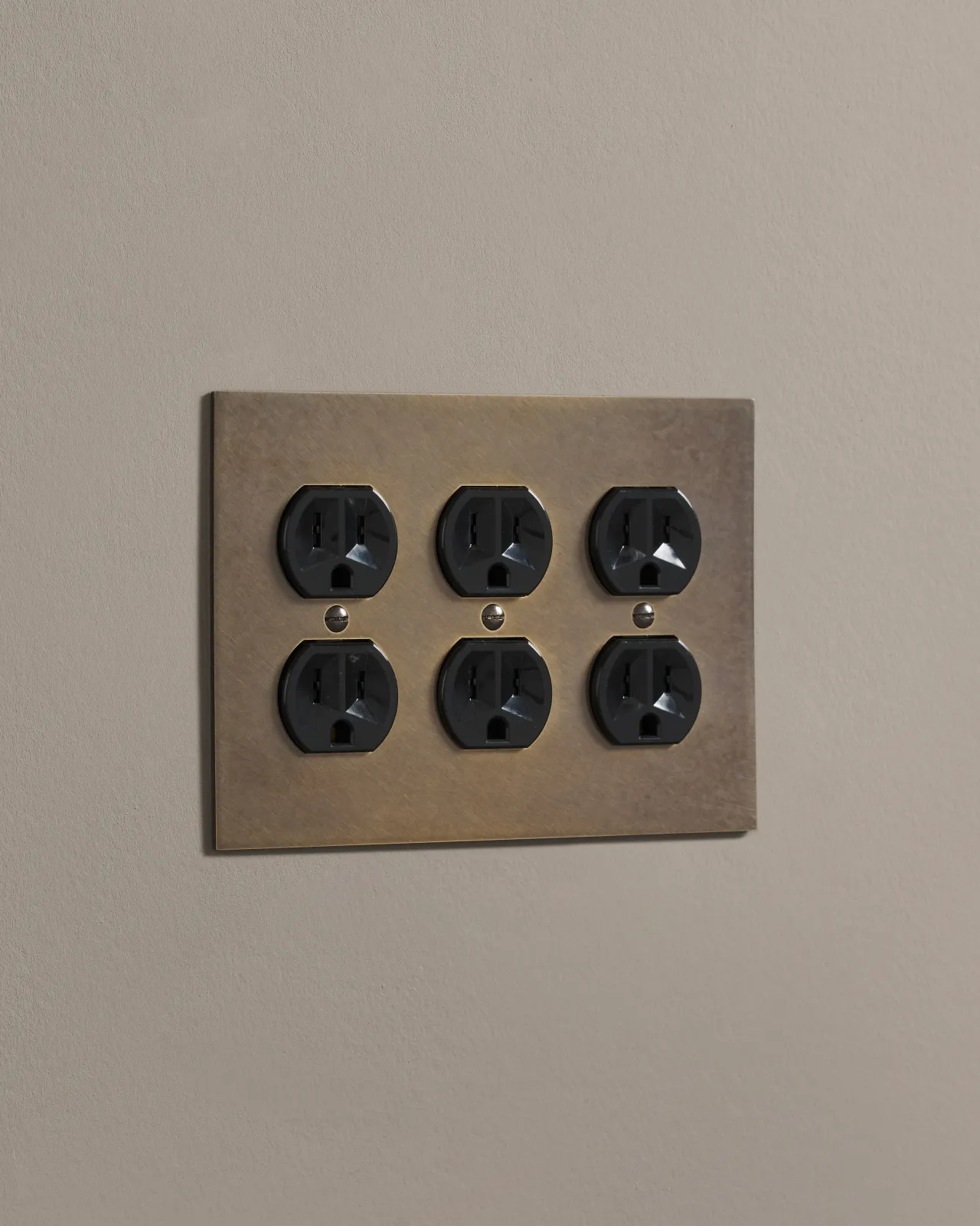 a side on shot of the duplex outlet on oxidised brass cover plate.