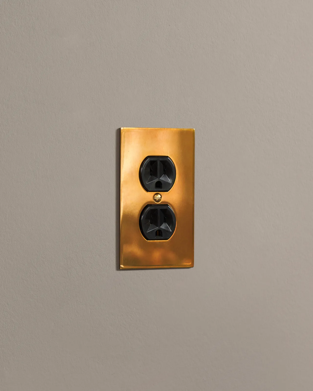 a side on shot of the duplex outlet on an heirloom brass cover plate.