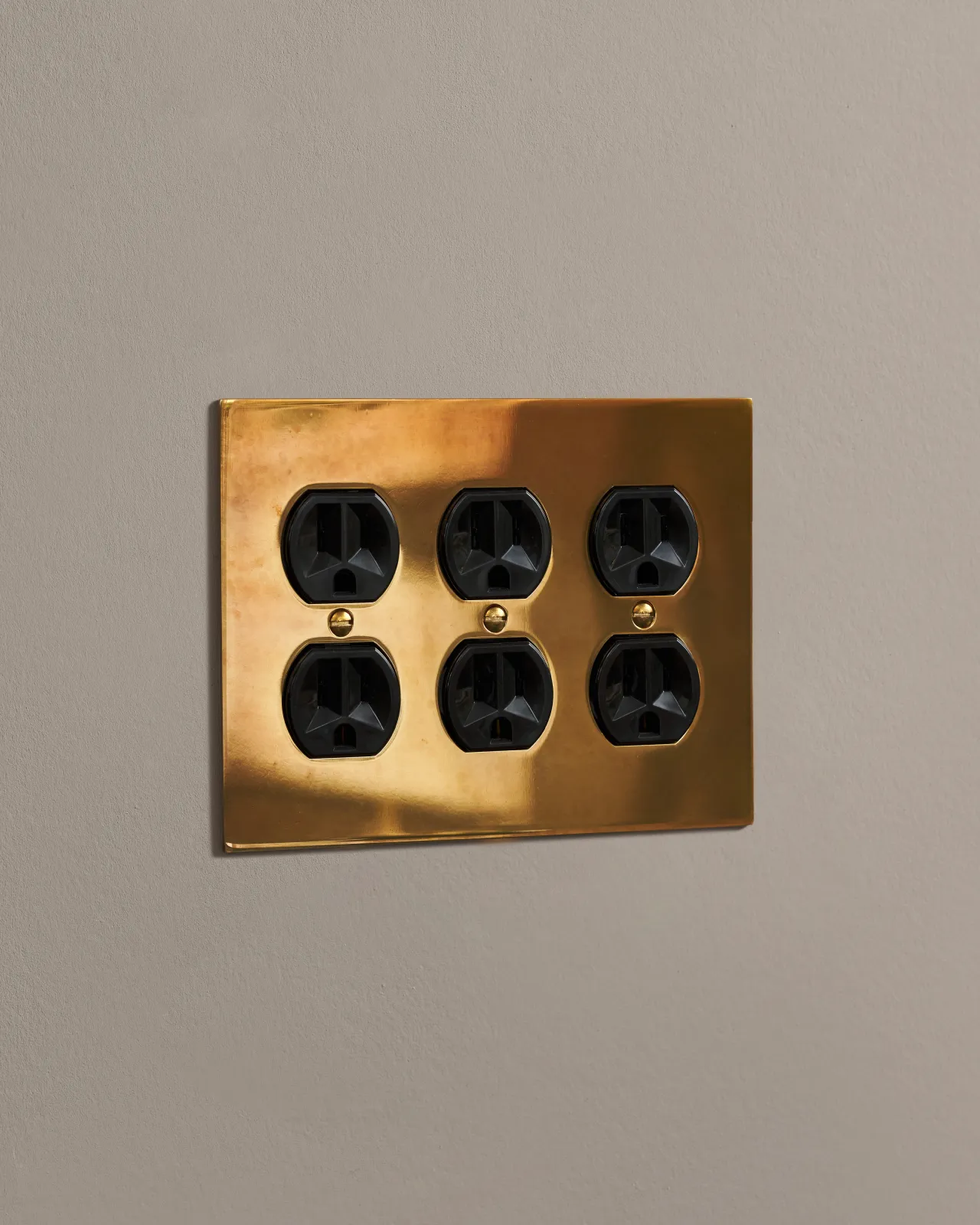 a side on shot of the duplex outlet on an heirloom brass cover plate.