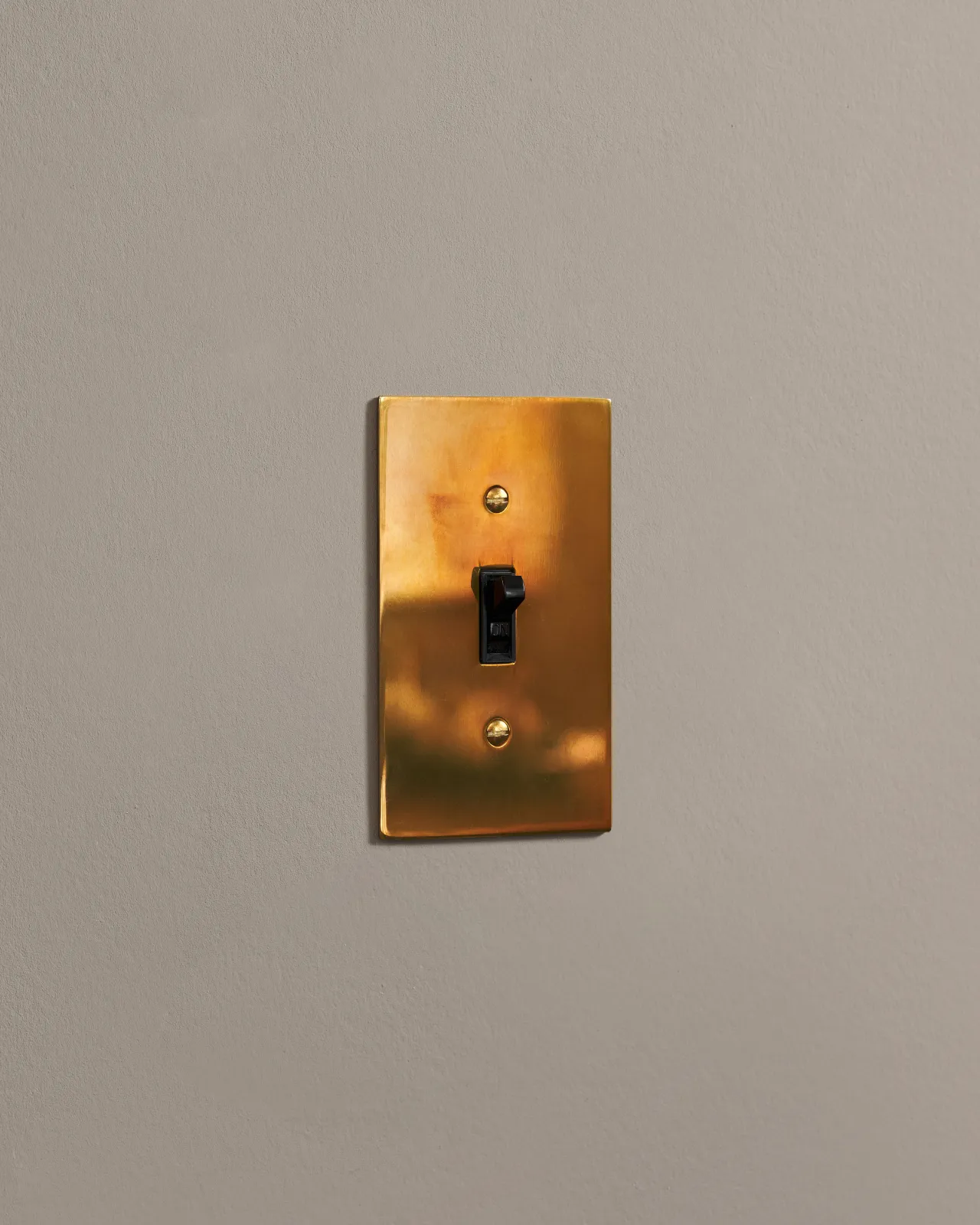 a side on shot of the toggle switch on an heirloom brass cover plate.
