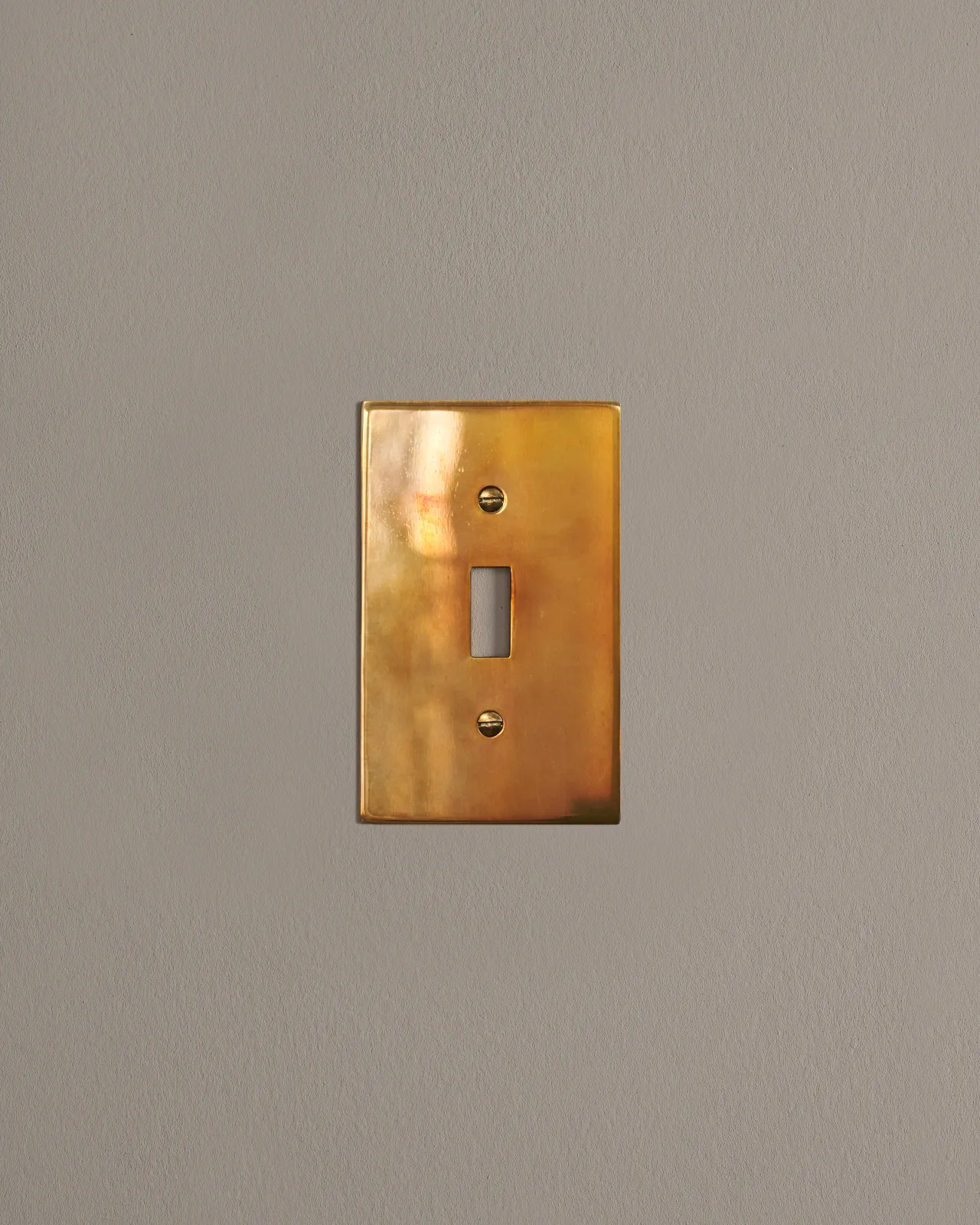 a front on shot of the toggle switch cover plate in heirloom brass.