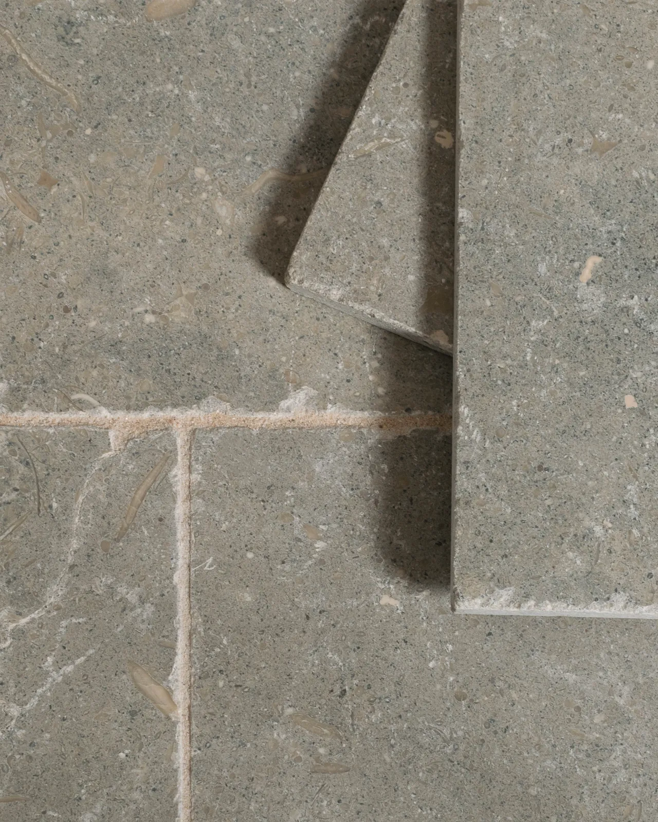 A close-up overhead view of Seagrass Tumbled Limestone flooring.