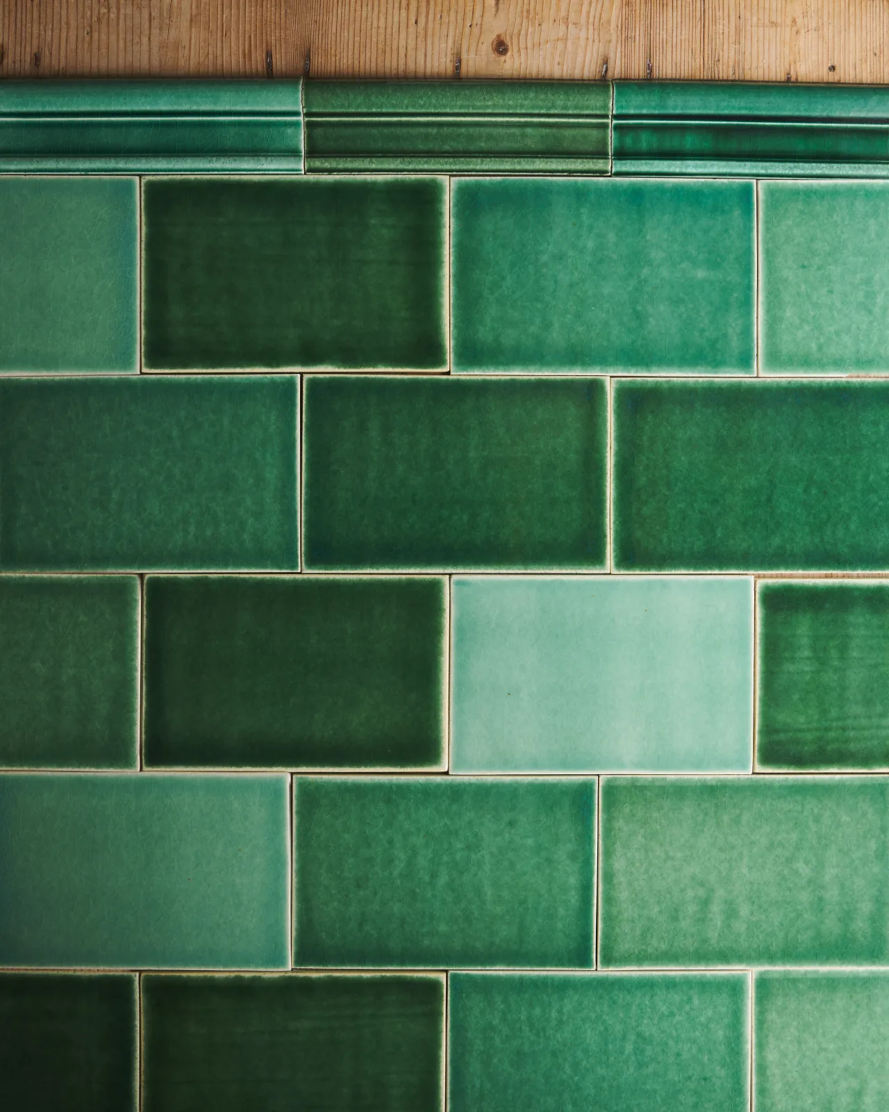 a top down view of a layout showing different shades of the emerald green tiles and border tiles.