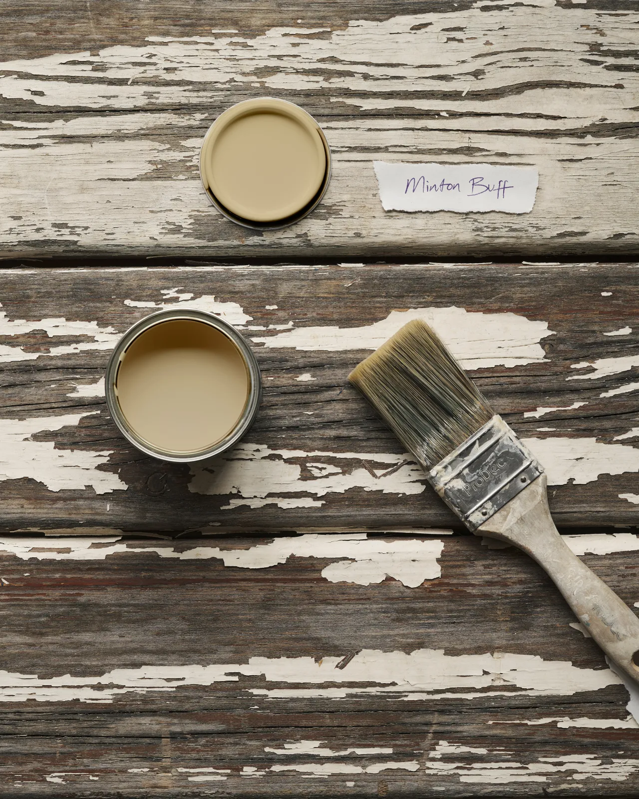 a top down image of a sample pot paint colour of a light yellow cream 
