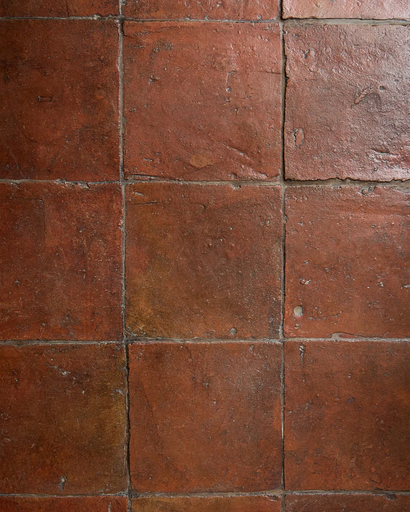 A flat lay image of the Terracotta Square tiles in the antique wax coating and mocha brown grout.