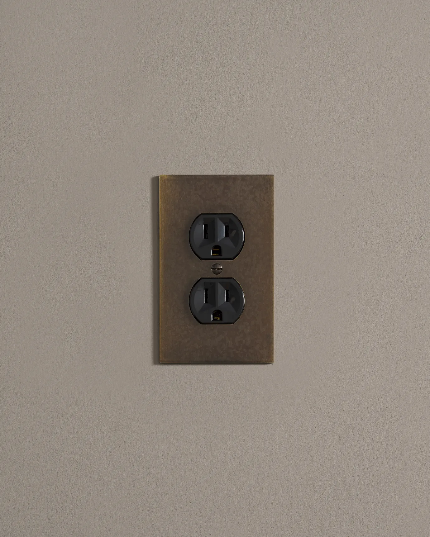 a front on shot of the duplex outlet on oxidised brass cover plate.