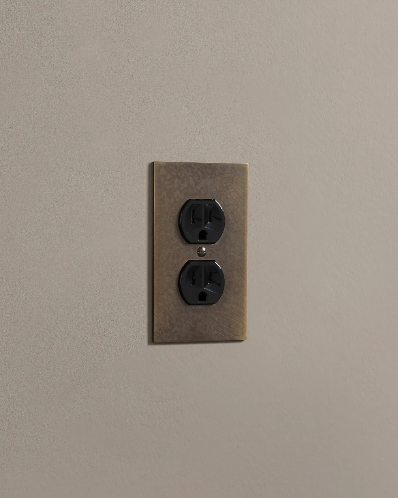 a side on shot of the duplex outlet on oxidised brass cover plate.