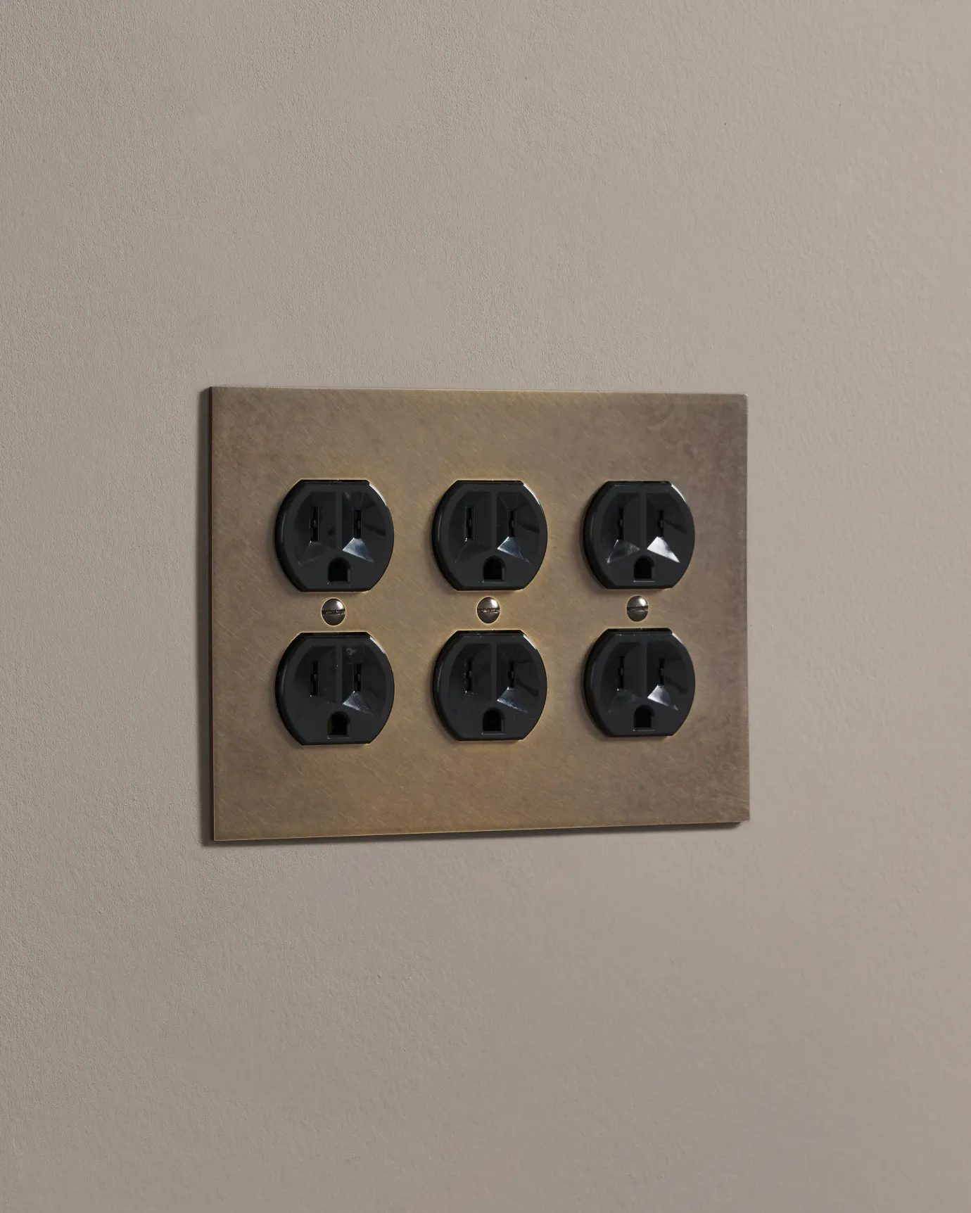 a side on shot of the duplex outlet on oxidised brass cover plate.