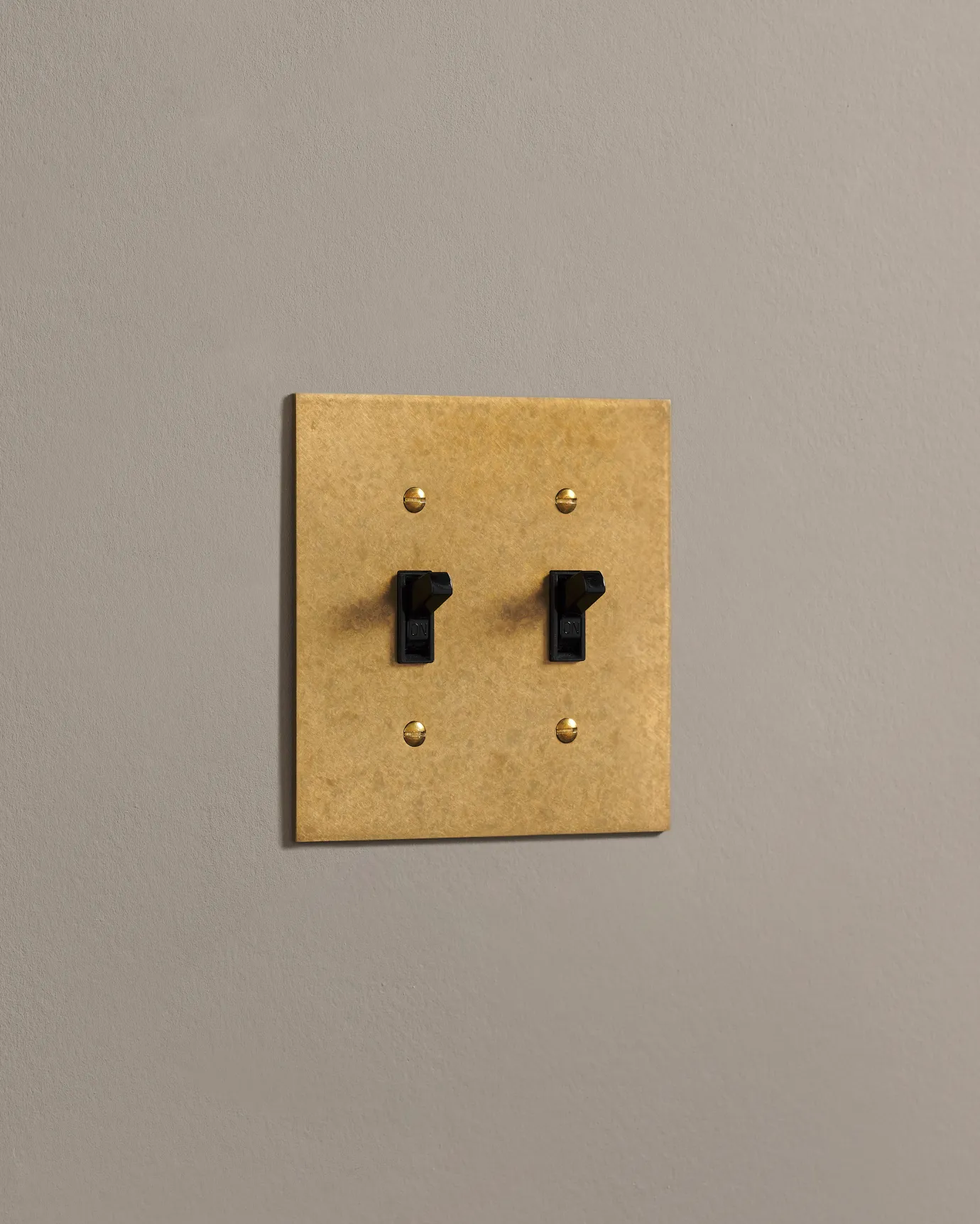A side on shot on a toggle switch on an aged brass cover plate.